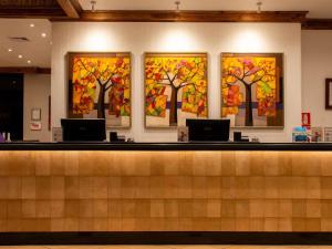 a lobby with three trees painted on the wall at Swissotel Quito in Quito +205 photos