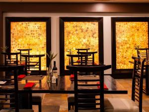a dining room with a table and chairs and windows at Swissotel Quito in Quito