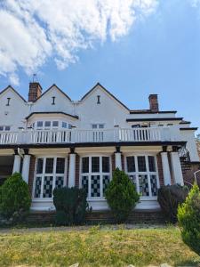 a large white house with large windows at Chartridge Lodge Hotel in Chesham