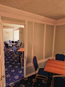 a waiting room with chairs and tables and tablesktop at Chartridge Lodge Hotel in Chesham