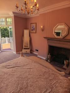 a bedroom with a bed and a fireplace at Chartridge Lodge Hotel in Chesham