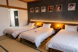 two beds in a hotel room with at Tomoeドットコム3 music stay in Hakodate