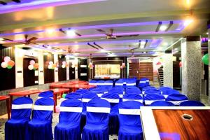 a room with blue chairs and tables in a restaurant at Hotel Glacier in Arāria