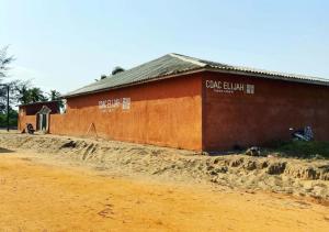 a building on the side of a dirt road at Appart'Haris in Ouidah +10 photos