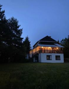 a large building with a deck on a field at NOCLEGI NOVA in Krasnobród