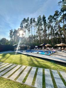 a swimming pool with people in it with trees at Leśne Ustronie in Lubiszewo