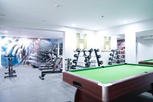a fitness room with a pool table and exercise equipment at فندق فربيون المجاردة - Ferbion Hotel Almajardah in Al Majaridah