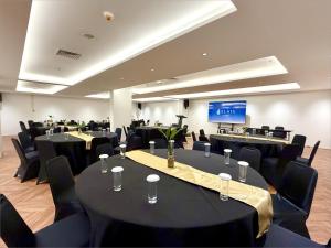 a conference room with black tables and black chairs at Elais by ARTOTEL in Medan