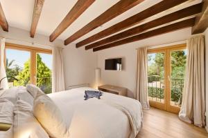 a bedroom with a large white bed and large windows at Fontsanta Hotel Thermal & Spa - Adults Only in Colònia de Sant Jordi