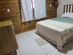 a bedroom with a bed and a wooden wall at Casa da Brisa in Salinópolis +8 photos