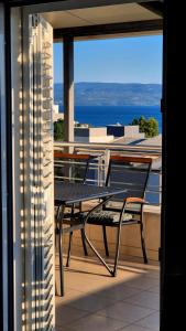 a table and chairs on a balcony with a view of the ocean at Sunshine Apartments Podstrana in Podstrana +14 photos
