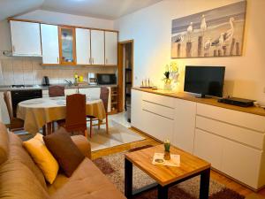 a kitchen and living room with a couch and a table at Sunshine Apartments Podstrana in Podstrana