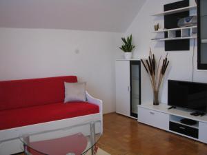 a living room with a red couch and a tv at Apartment Marinka in Bled