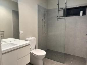 a bathroom with a shower and a toilet and a sink at Central 3BR Home in Mansfield +4 photos