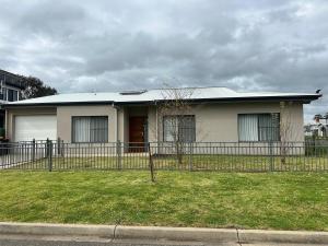 a white house with a fence in front of it at Central 3BR Home in Mansfield