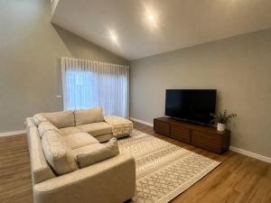 a living room with a couch and a flat screen tv at Central 3BR Home in Mansfield