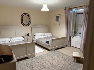 a bedroom with two beds and a mirror at Chez Paulet A welcome break for peace and tranquility - route C27 in Lobard