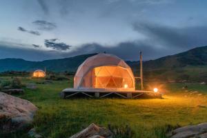 two tents sitting in a field at night at Old stones glamping in Chok-Tal