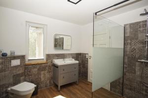 a bathroom with a toilet and a sink and a shower at Ferienwohnung Irmchen in Altefähr +27 photos