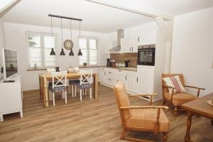 a kitchen and dining room with a table and chairs at Ferienwohnung Irmchen in Altefähr