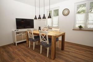 a dining room with a wooden table and chairs at Ferienwohnung Irmchen in Altefähr