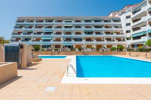 a swimming pool in front of a large building at Atlantic Sky Panorama in Costa Del Silencio