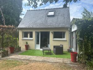 a small house with a green lawn in front of it at Hortensia in Carnoët
