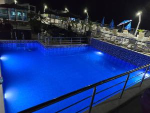 a large blue swimming pool at night at Apartments Mekic in Utjeha