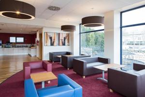 a waiting room with couches and tables and windows at Travelodge Barcelona Fira in Hospitalet de Llobregat