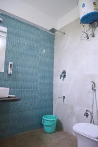 a bathroom with a blue toilet and a sink at Hotel Atithya in Udaipur
