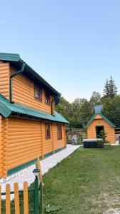 a wooden house with a fence in front of it at Mountain Paradise House in Žabljak