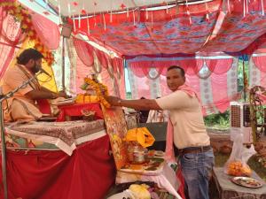 a man is standing in front of a tent at Hotel Kunj Palace in Etah