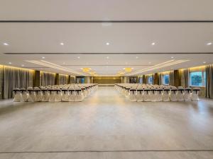 an empty ballroom with rows of chairs and tables at Jain Tree by Spree Hotels Vellore in Vellore