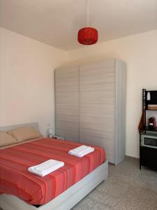 a bedroom with a large bed with a red blanket at Nonna Consolata Studio - 25 min to Cagliari & Beaches in Dolianova