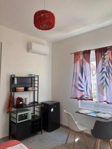 a room with a desk and a table and a window at Nonna Consolata Studio - 25 min to Cagliari & Beaches in Dolianova