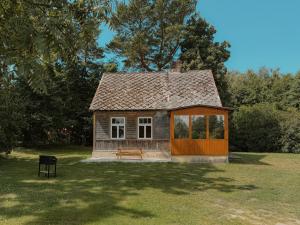a small house with a bench in a field at Ligzdiņas in Bernāti
