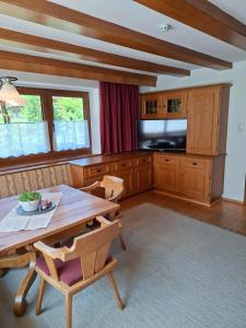 a living room with a wooden table and a television at Landhaus Gollner in Uderns