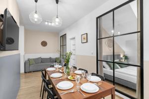 a dining room with a table and chairs and a living room at Friendhouse Residence in Krakow