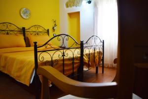 una camera da letto con un letto nero e pareti gialle di B&B Salotto Di Athena a Agrigento