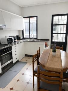 a kitchen with a table and chairs and a kitchen with white cabinets at Apartamentos Campus Arzúa in Arzúa