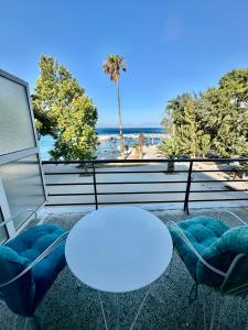 two tables and chairs in a room with a view of the beach at Hotel Akti in Loutraki