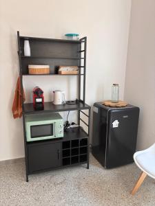 a black shelf with a microwave and a refrigerator at Nonna Consolata Studio - 25 min to Cagliari & Beaches in Dolianova