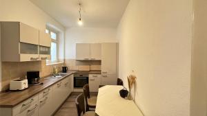 a kitchen with a table and some chairs in it at Holstentor Apartment in Lübeck