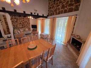 a dining room and living room with a table and chairs at Lithos Villas Komitsa in Metókhion Koumítsas
