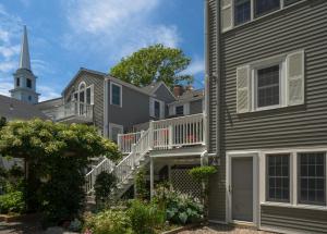 a row of houses with a church in the background at Old Harbor Inn in Chatham