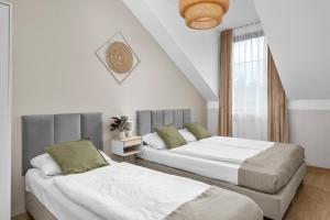 two beds in a room with white walls at Friendhouse Residence in Krakow