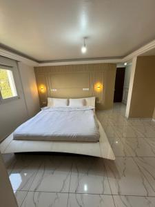 a bedroom with a large bed in a room at Le Conviviall in Yaoundé