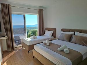 a hotel room with two beds and a large window at Villa Dedi ,Borsh in Vane