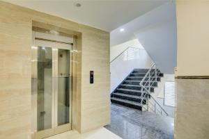 a staircase in a house with a glass elevator at Hotel Smart Premier -Delhi Airport in Behror +19 photos