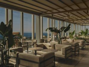a hotel lobby with couches and tables and windows at Meliá Barcelona Sky 4 Sup in Barcelona